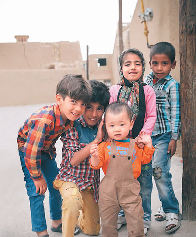 在伊朗亚兹德老城,当地小孩和贩暖的儿子开心玩耍.