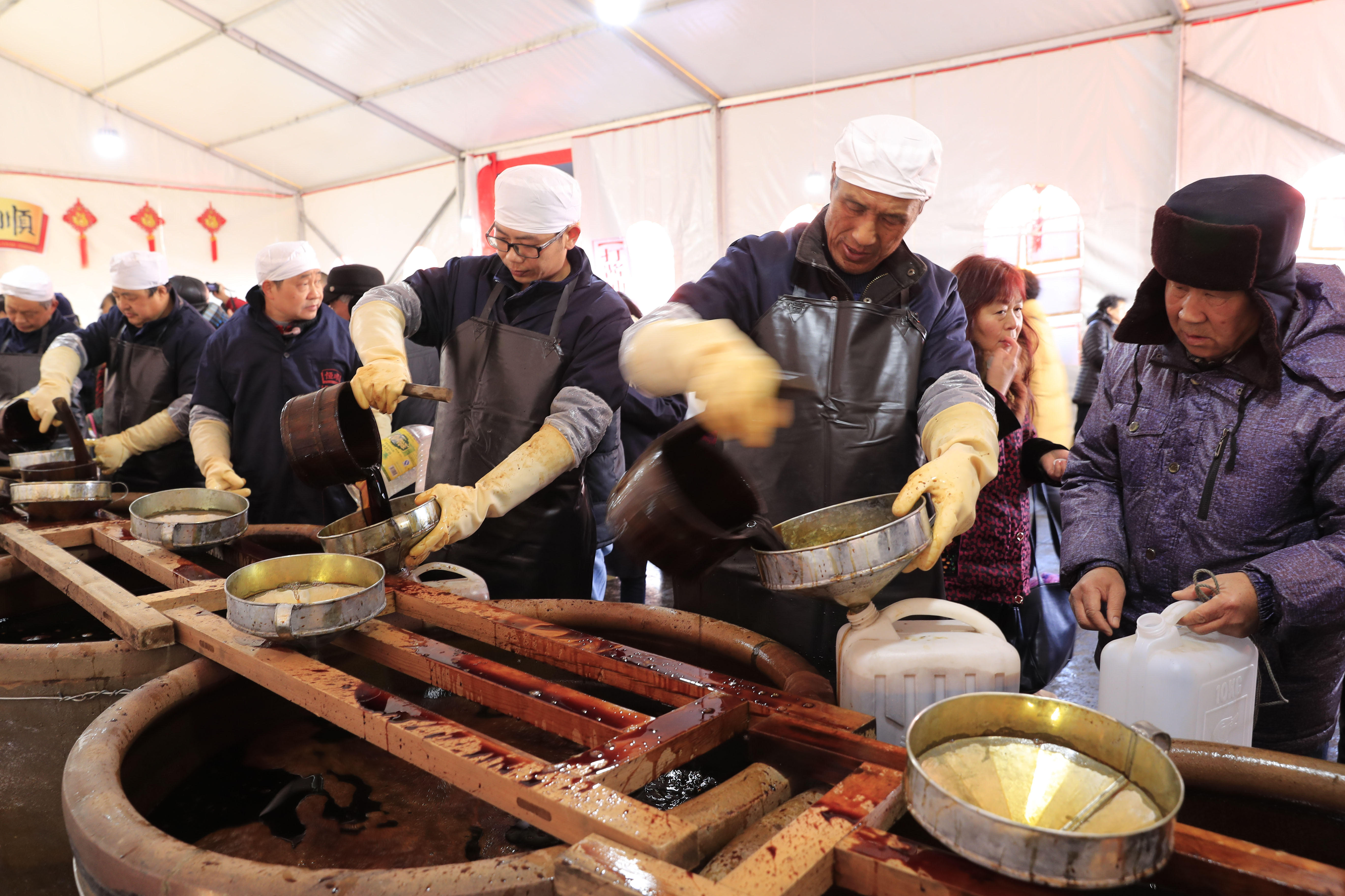 老字号酱醋生产企业酱油春供活动拉开帷幕,众多市民排队"打酱油"及
