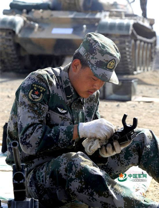 对机枪部件进行细致擦拭.下士王开对自己心爱的战车进行擦拭.