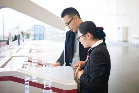 苏州中行工作人员协助客户使用智能柜台办理业务