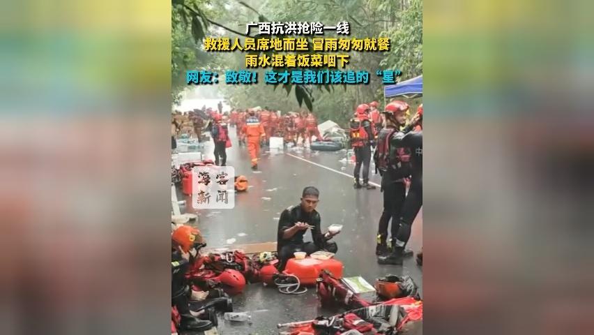 广西抗洪抢险一线 救援人员席地而坐冒雨匆匆就餐 雨水混着饭菜咽下