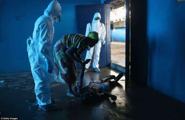 利比里亚,埃博拉病房,一名男子昏迷跌倒了,他的妻子正双手捂头站在其