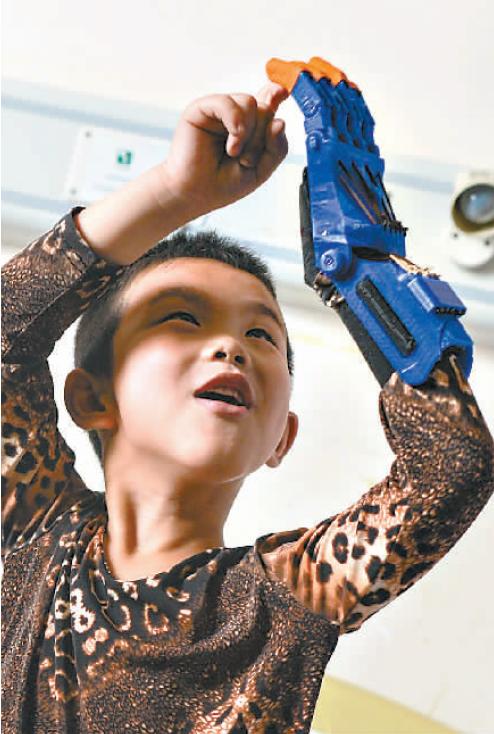 河南无手男孩在汉装上3d打印手轻松骑车拿葡萄