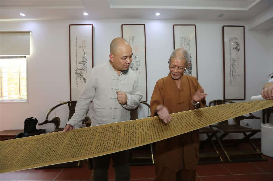 杭州十竹斋斋主魏立中(左)向开元寺方丈道元大和尚展示由他复刻的雕版