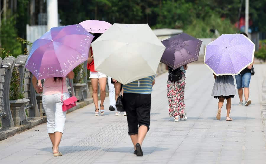 8月8日,在广西南宁市那平江桥上,出行市民撑伞遮阳