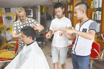9月8日见到李祝平时,他正在为客人理发,两名失聪徒弟在他身边学习李 