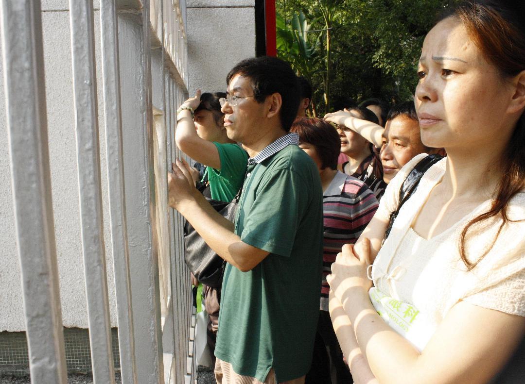 3：家长们坚守在隔栏外为孩子祈祷。记者王益群摄.JPG