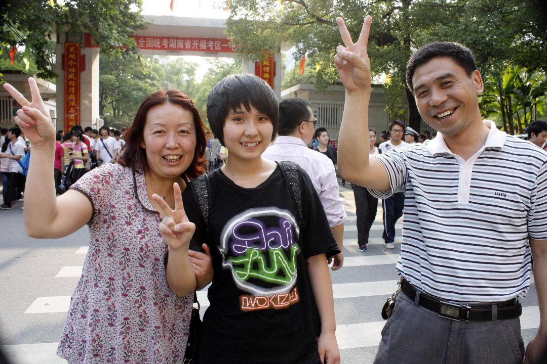 1：父母用“胜利”的手势期望女考出好成绩。记者王益群摄.JPG